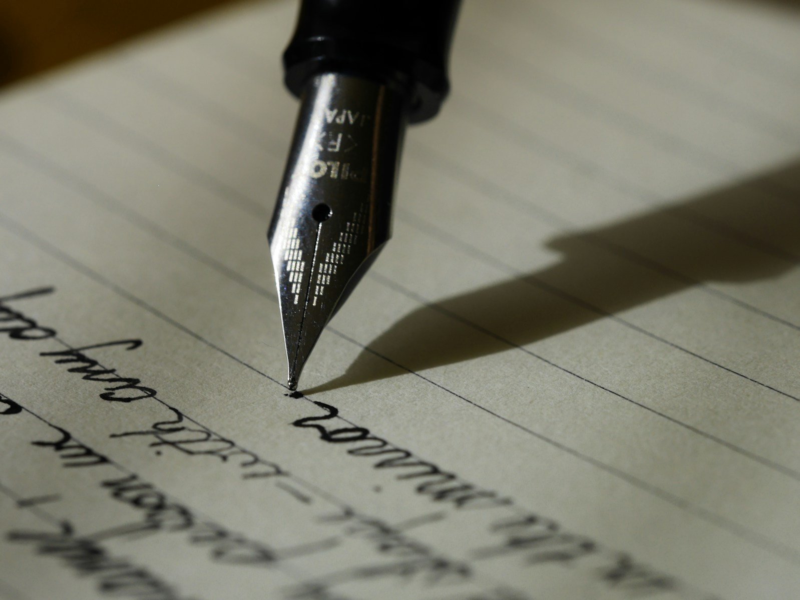 Contacto Abogado Motero Huelva fountain pen on black lined paper